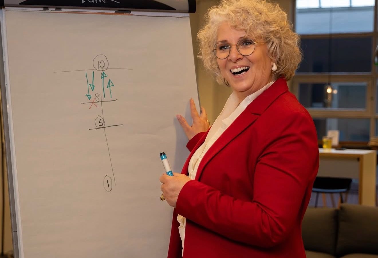 Will Hut-Doornik geeft lachend een workshop bij een flip-over